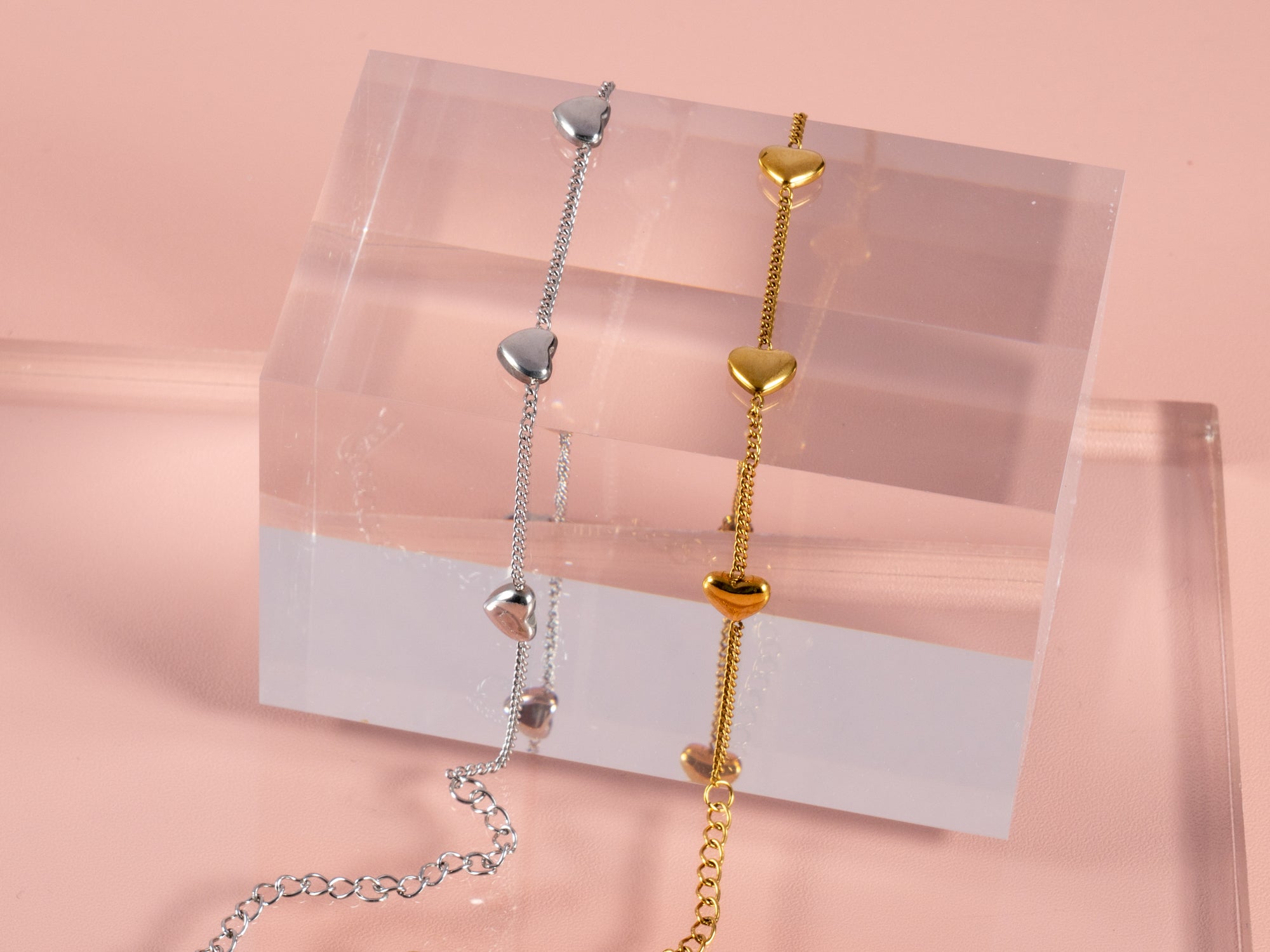 multi heart gift bracelets shown here on a clear cube and a pink bridesmaid can't tie the knot without you gift pouch next to it. These are great gift bracelets for all your bridesmaids