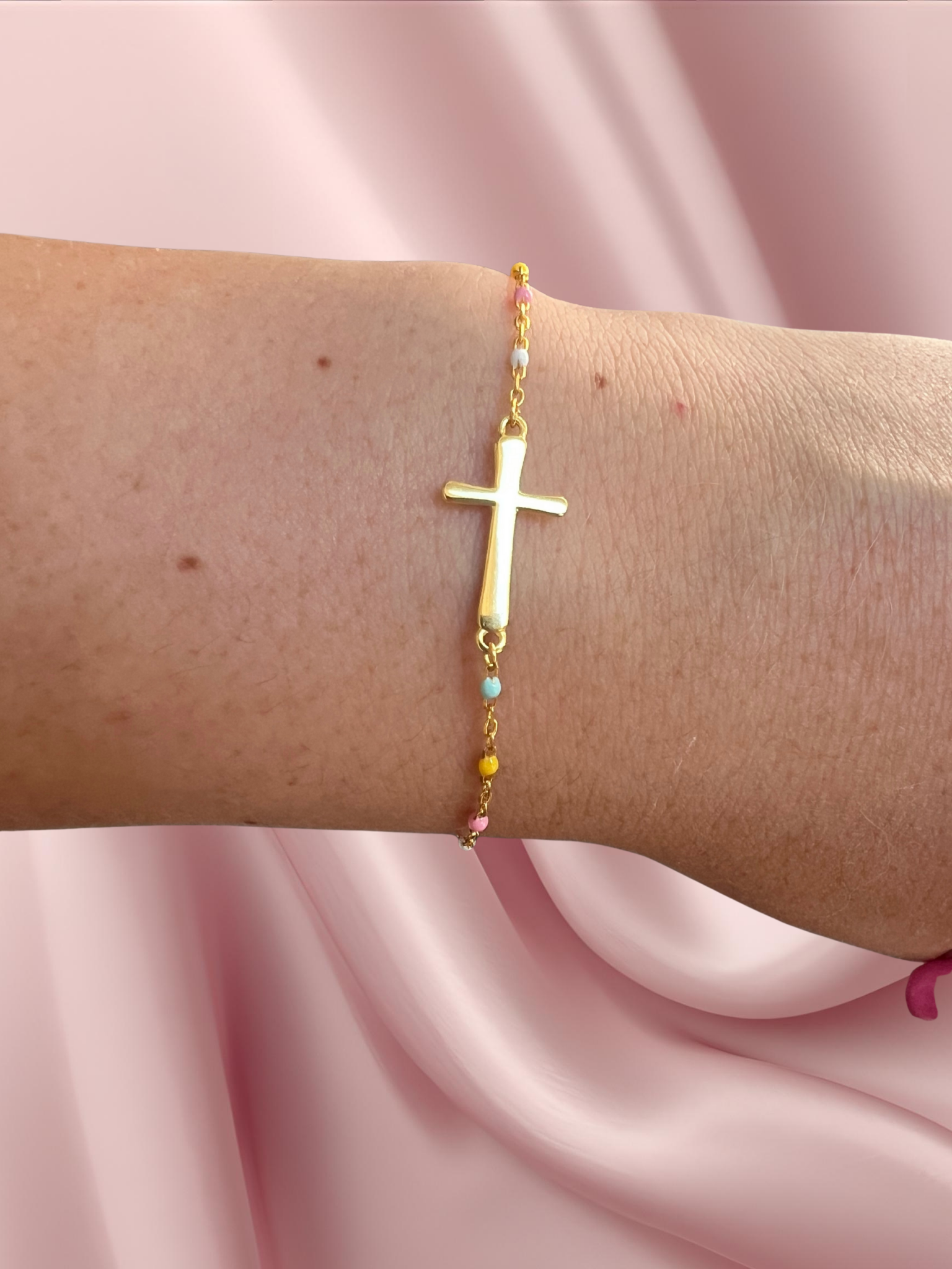 gold cross bracelet shown on a wrist and can be given as a bride congrats gift to the bride to be or for a wedding gift for the bride or for a bridesmaid proposal box