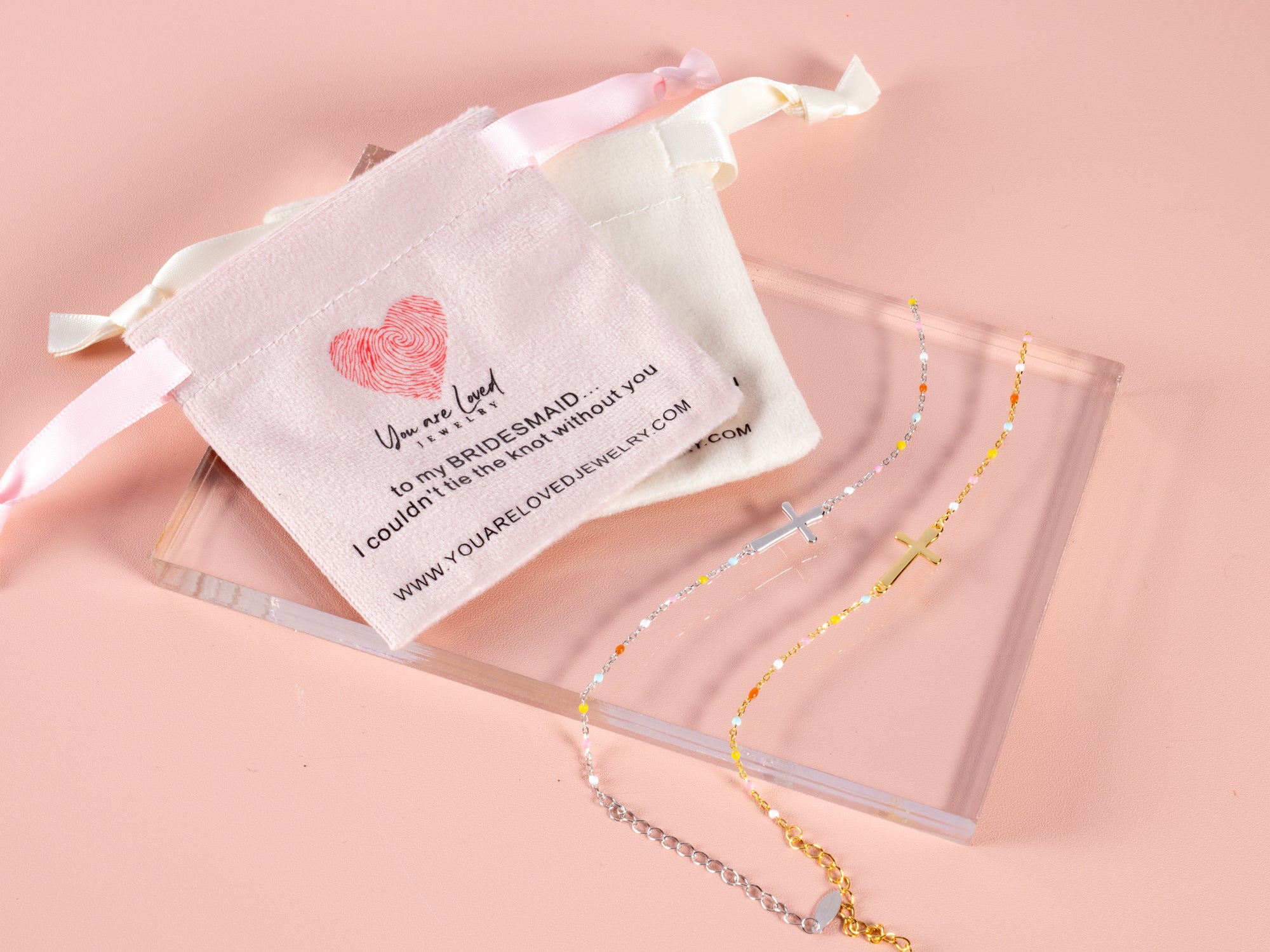 gold and silver cross bracelets shown here with a can't tie the knot without you pouch makes a great gift for a bridesmaid proposal box