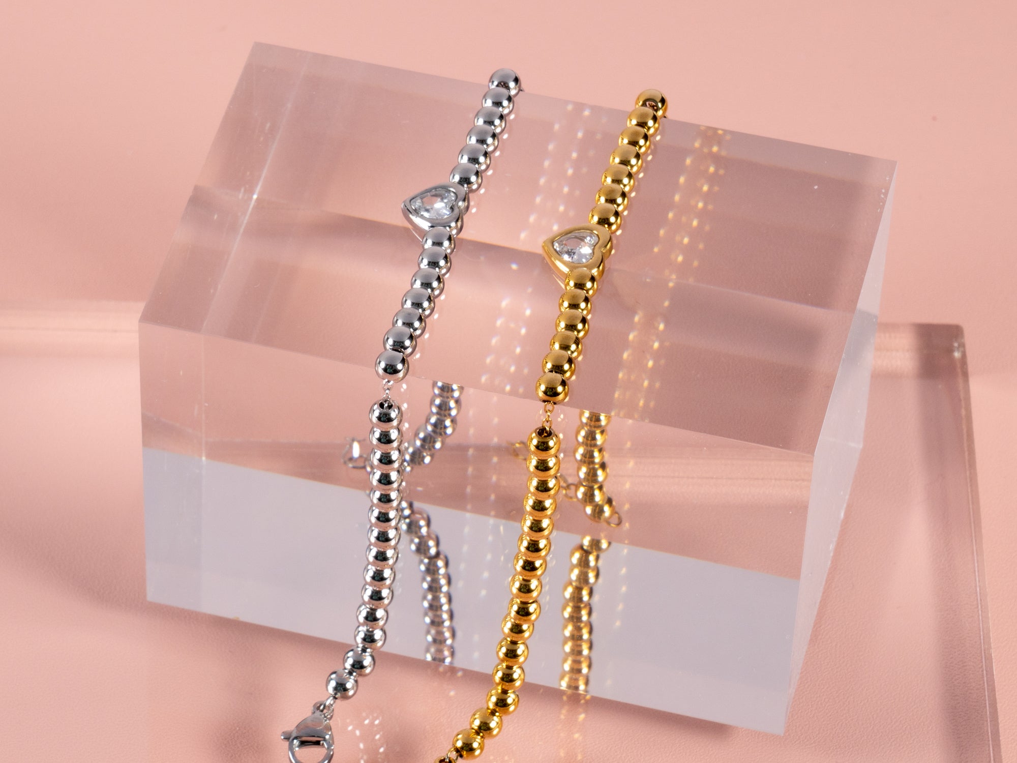 close up showing two heart gemstone bracelets one in silver and one in gold and can be given as gifts to brides or bridesmaids