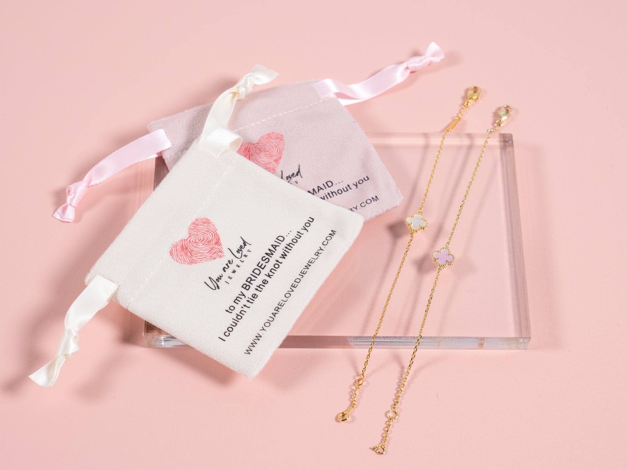 pink or white four leaf clover charm bracelets that come with a velvet pouch that says can't tie the knot without you it is a great gift idea for bridesmaids