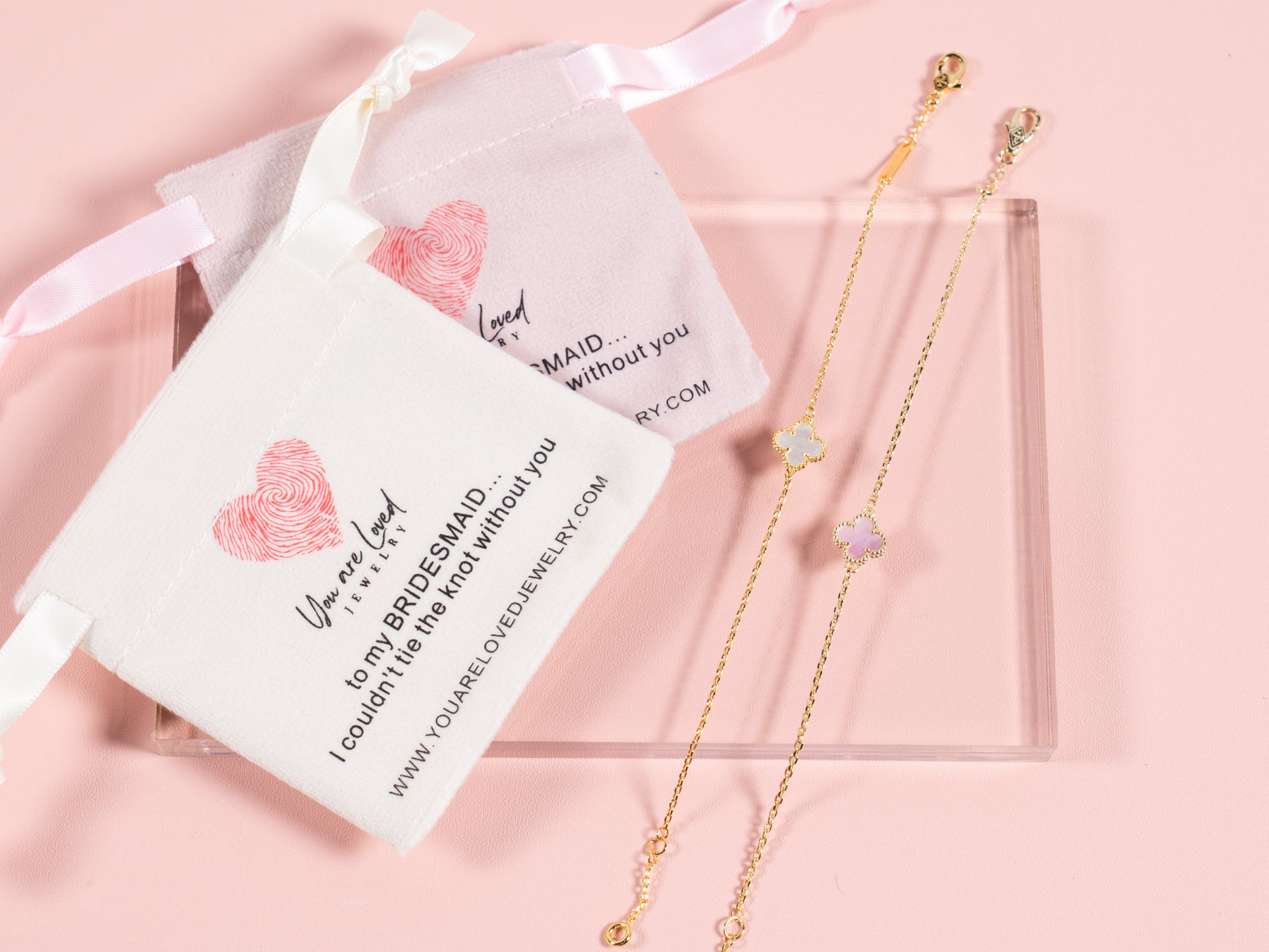 pink or white four leaf clover charm bracelets that come with a velvet pouch that says can't tie the knot without you it is a great gift idea for bridesmaids