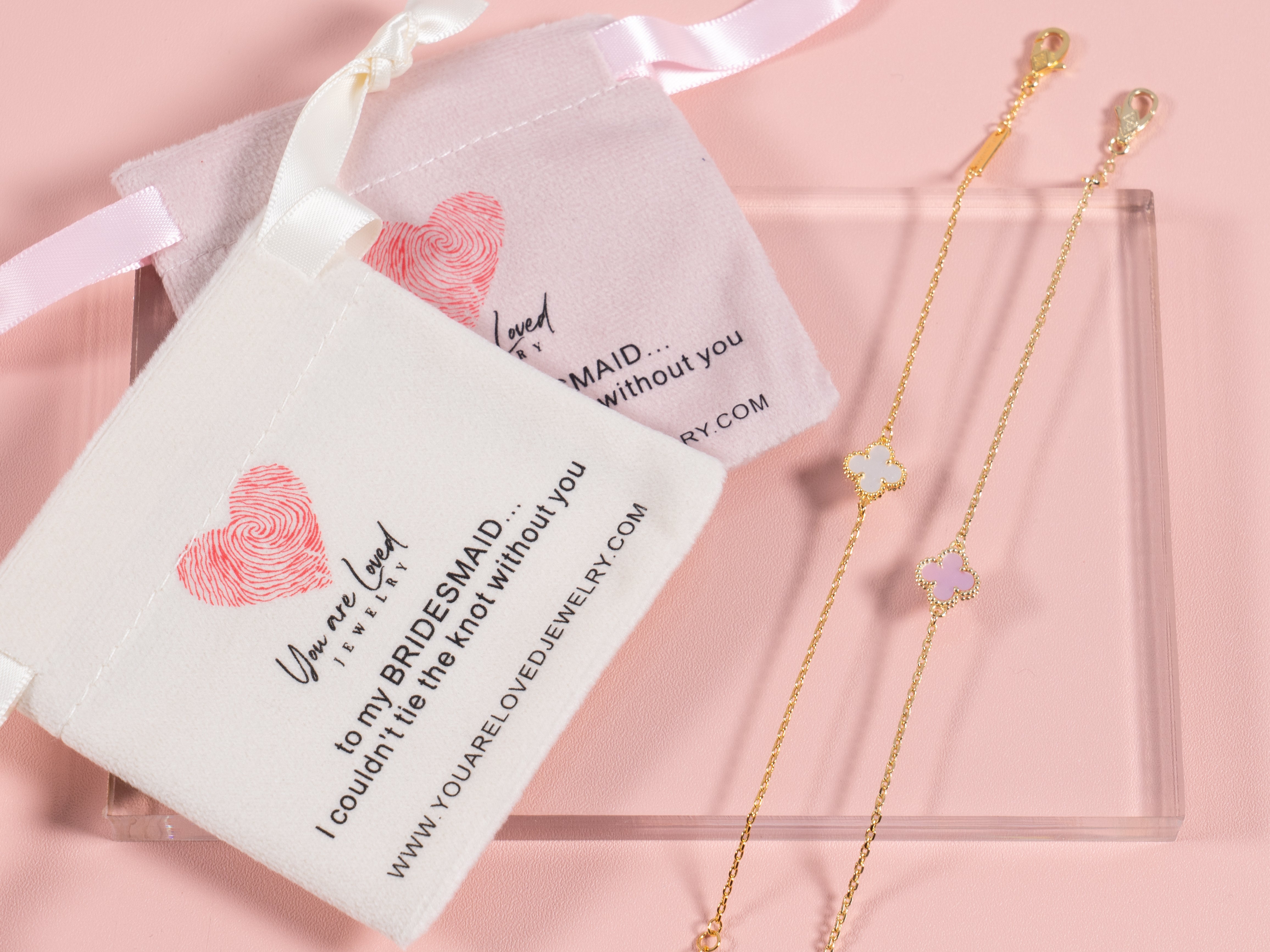 pink or white four leaf clover charm bracelets that come with a velvet pouch that says can't tie the knot without you it is a great gift idea for bridesmaids