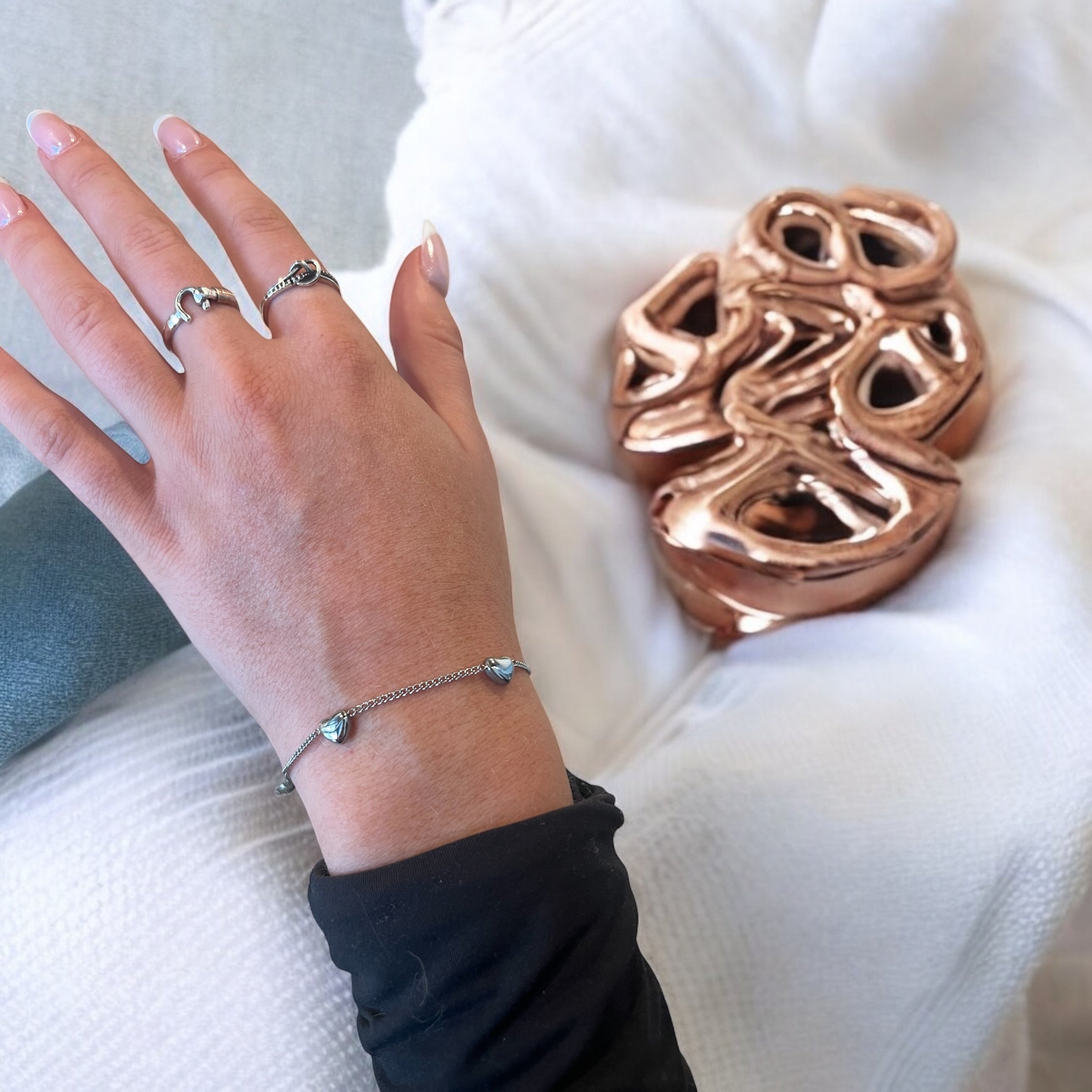 multi heart gift bracelets shown here on a clear cube and a pink bridesmaid can't tie the knot without you gift pouch next to it. These are great gift bracelets for all your bridesmaids